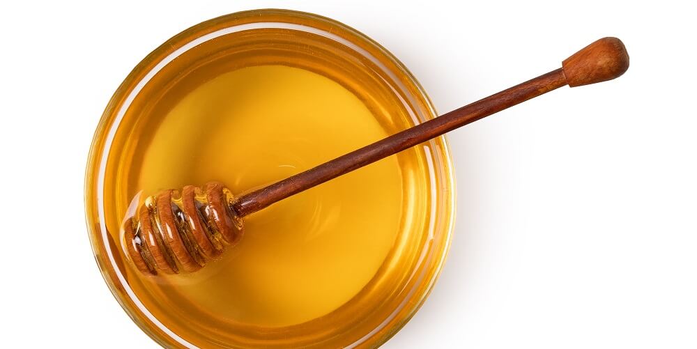 honey and honeystick in bowl