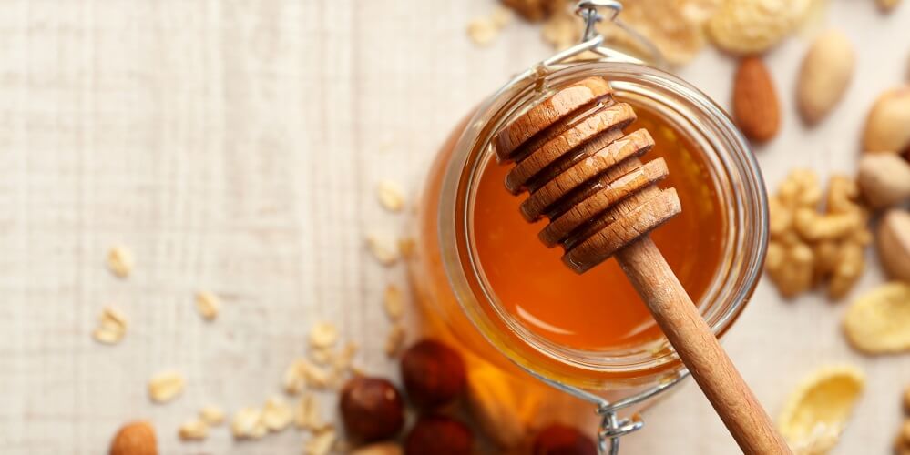 jar of honey with honeystick