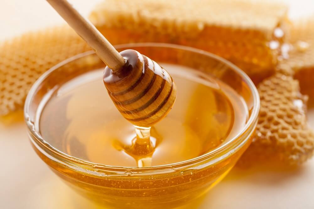 honey dipper in bowl of honey